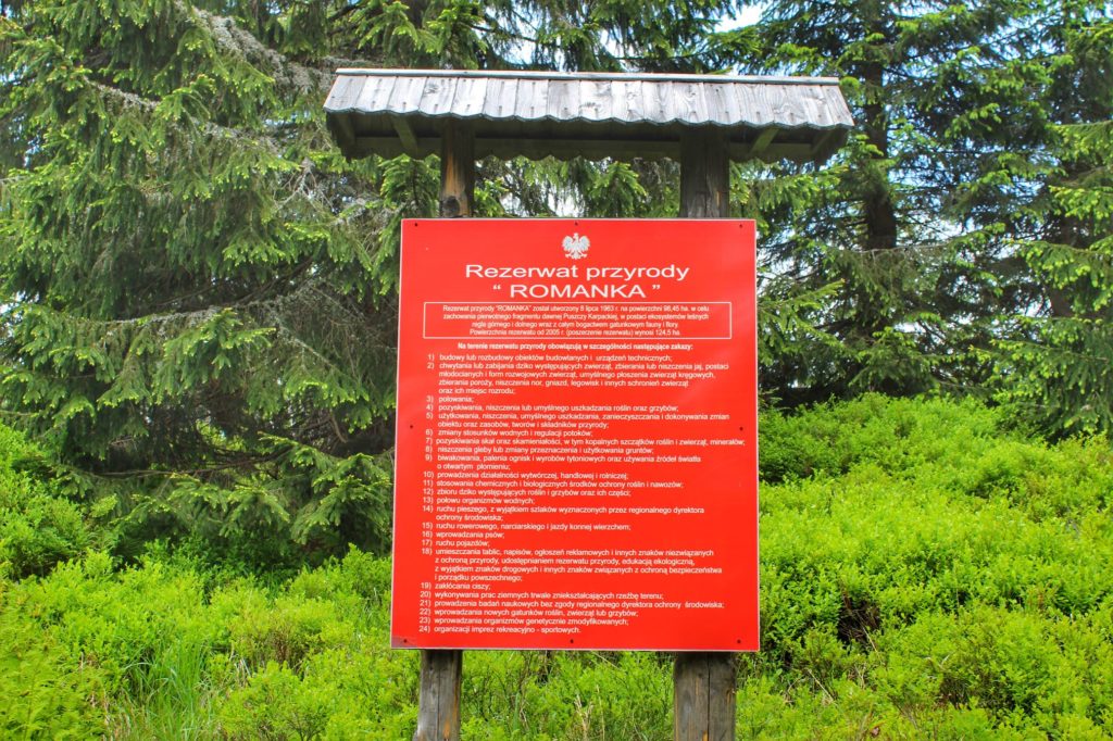 Czerwona tablica z napisem Rezerwat przyrody ROMANKA