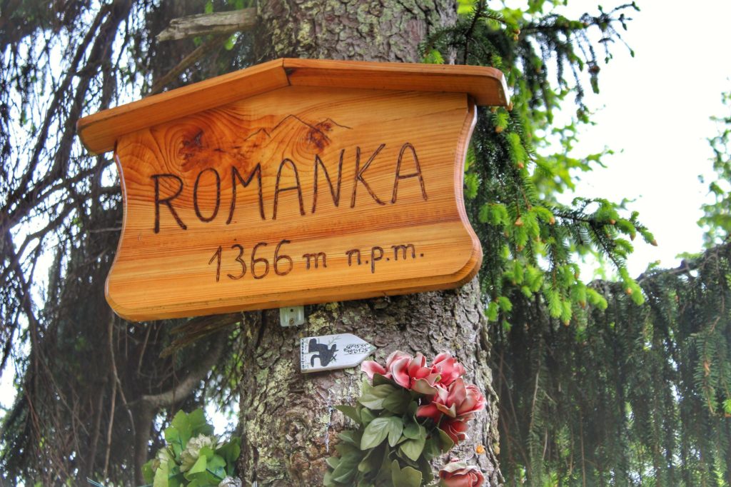 Drewniana tabliczka z napisem ROMANKA 1366 m n.p.m. wisząca na drzewie