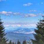 Widok na Tatry na tle niebieskiego nieba z zielonego szlaku na odcinku Rysianka - Hala Lipowska