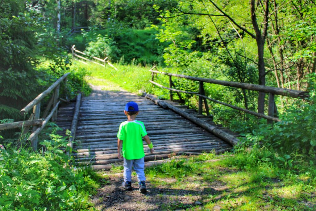 Dziecko przechodzi przez drewniany mostek w Stryszawie