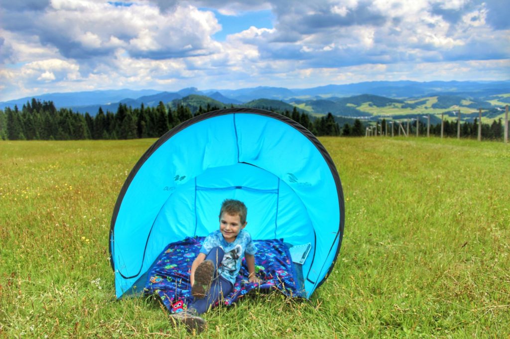 Dziecko siedzące w namiocie na polanie na szlaku żółtym prowadzącym na Żar w Pieninach