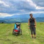 Turysta z dzieckiem w wózku na polanie w Pieninach, widok górski