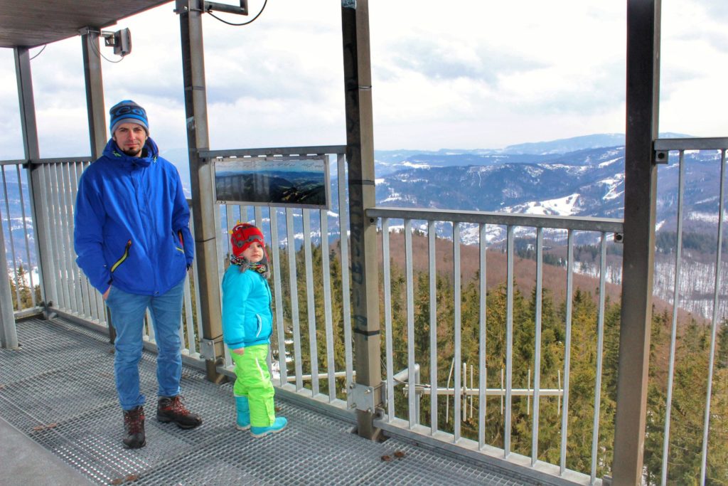 Dziecko z tatą na wieży widokowej na Wielkiej Czantorii, widok na zaśnieżone góry