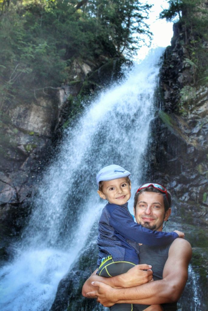 Zadowolone dziecko na rękach taty orzy zjawiskowym Wodospadzie Rohackim