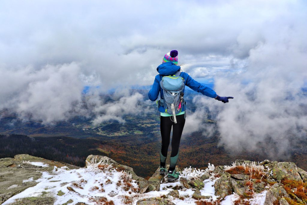 kobieta na tle krajobrazu górskiego, unoszące się chmury