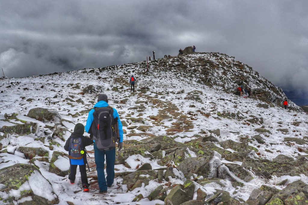mężczyzna z dzieckiem pokonujący ostatnie podejście na szczyt Babiej Góry, skały, kamienie ośnieżone,