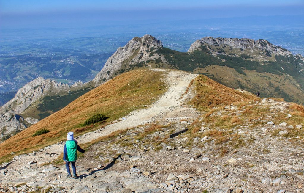 Dziecko schodzące z Kopy Kondrackiej w kierunku Kondrackiej Przełęczy, widok na Giewontu