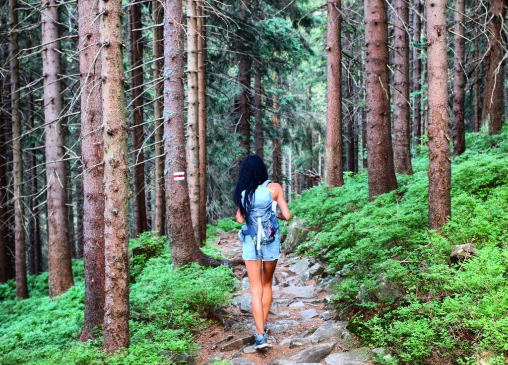 Kobieta idąca przez Las Suchowarski - szlak czerwony