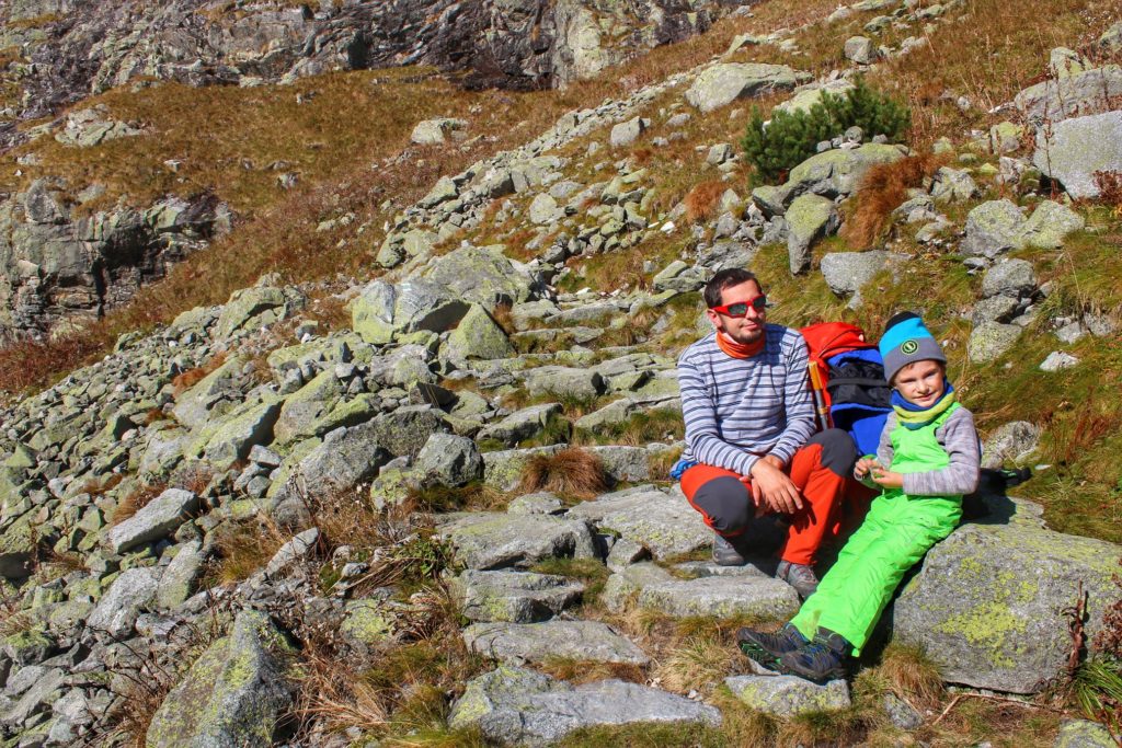 Dziecko odpoczywające z tatą na skałach w Tatrach Wysokich na szlaku prowadzącym do wodospadu Wielka Siklawa
