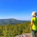 Dziecko podziwiające najwyższy szczyt Beskidu Śląskiego - Skrzyczne z Magurki Radziechowskiej, piękny słoneczny dzień