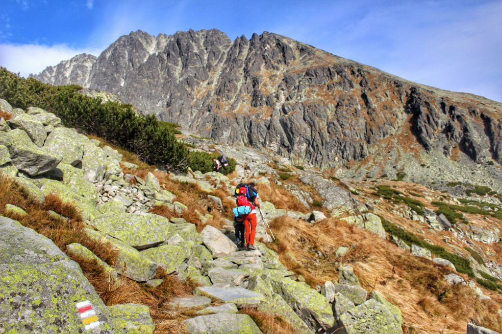 Turysta z dzieckiem, w tle ściana szczytu Gerlach, skalne podejście