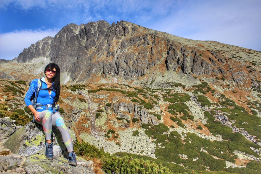 Turystka odpoczywająca na skale pod szczytem Gerlach, piękne, niebieskie niebo