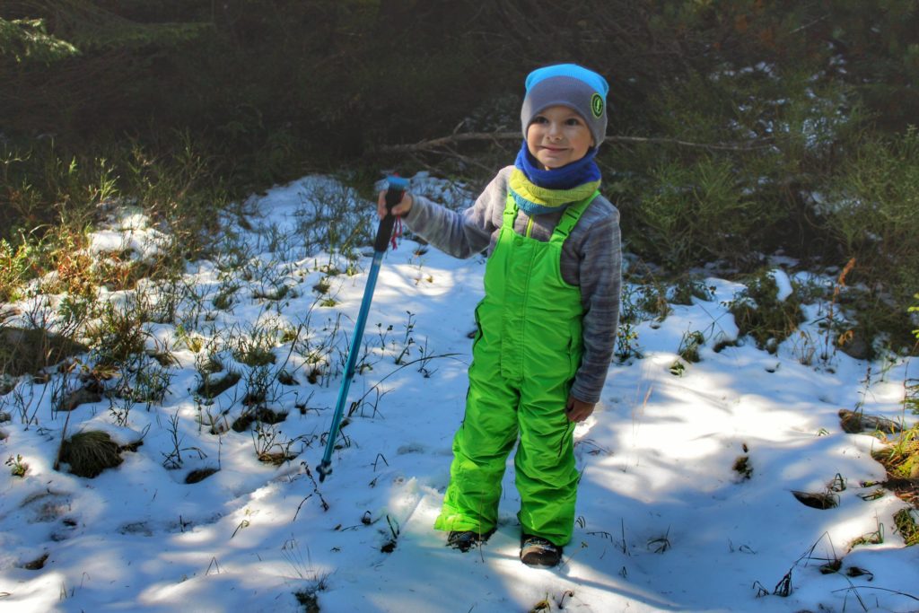 Zadowolone dziecko bawiące się w śniegu, las w Wielickiej Dolinie