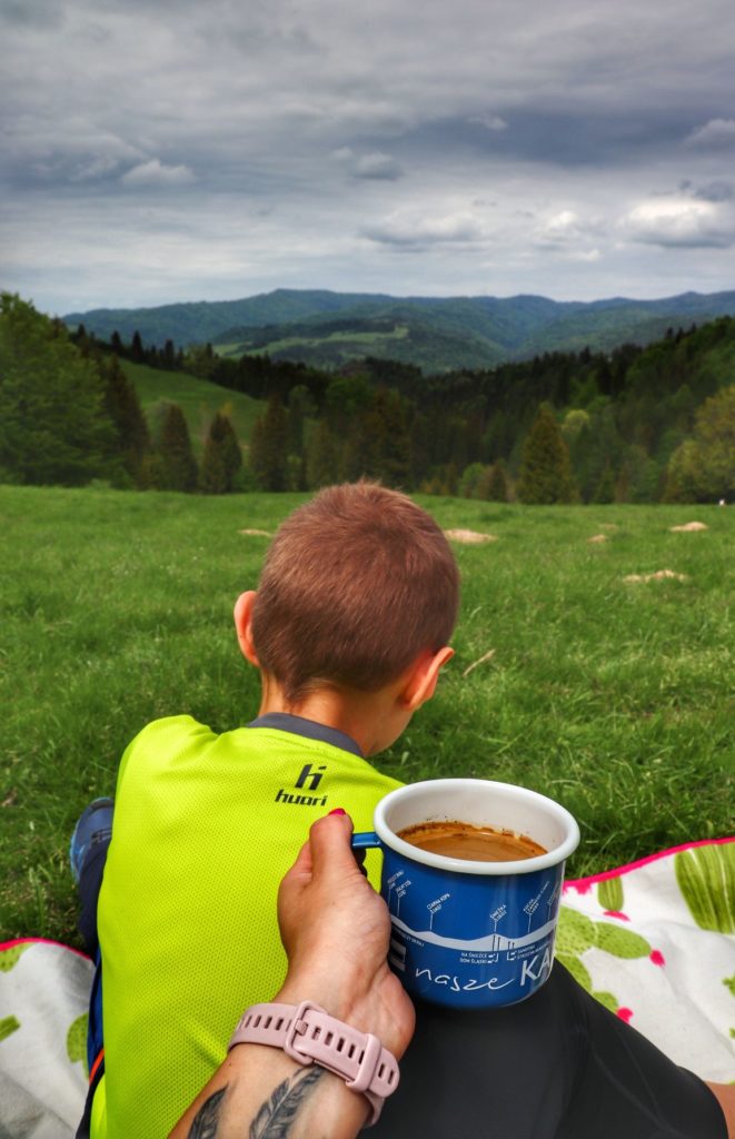 Dziecko odpoczywające na kocu na Polanie pod Wysoką, turystka z kawą