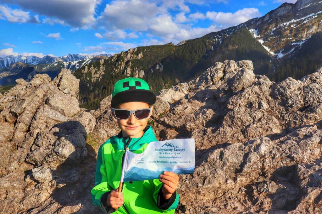 Sarnia Skała w Tatrach Zachodnich, uśmiechnięte dziecko siedzące na skałach, piękny widok na Tatry