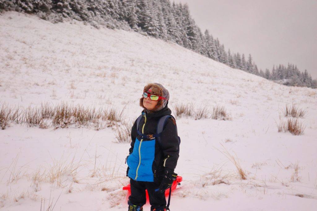uśmiechnięte dziecko w okularach słonecznych na Polanie Kopieniec, w koło śnieg, zima