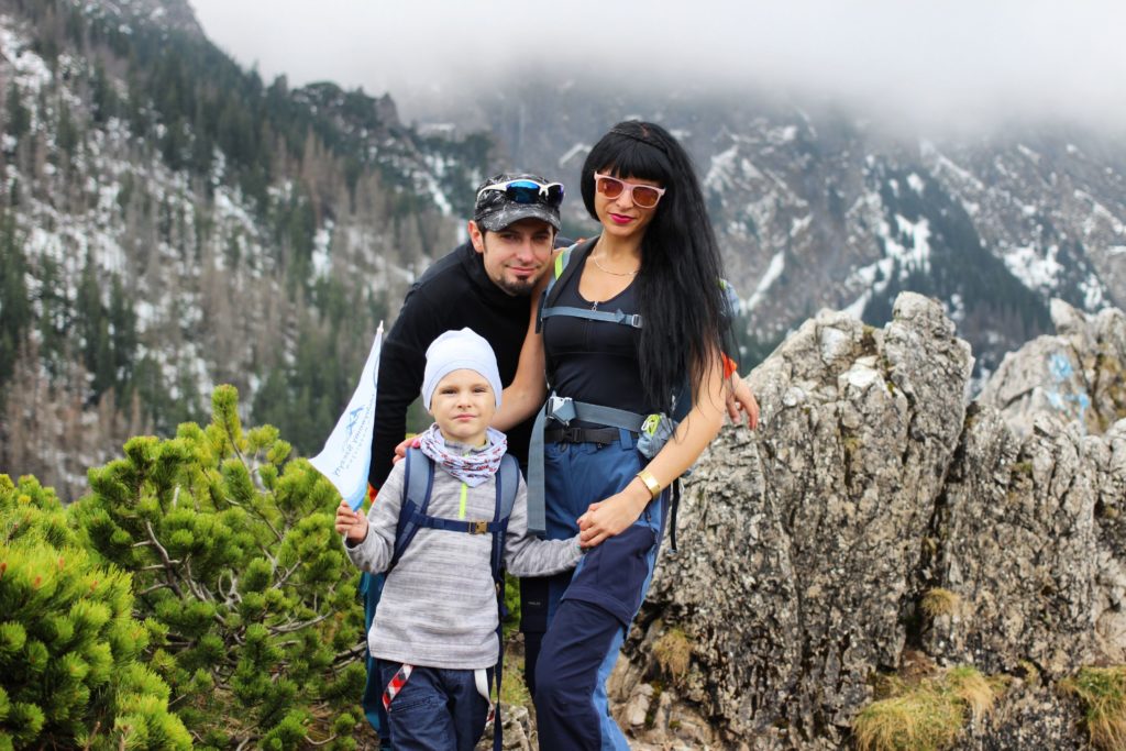 trzyosobowa rodzina z dzieckiem na tle tatrzańskich szczytów na górze Sarnia Skała