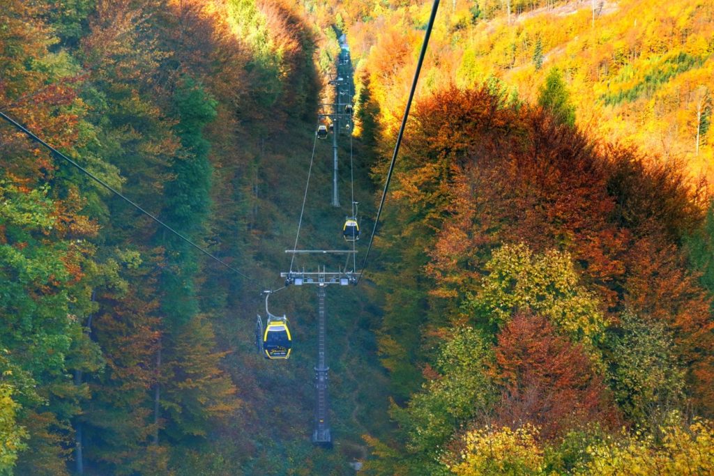 Żółte wagoniki - kolej linowa na Szyndzielnię w Bielsku-Białej, kolorowe liście na drzewach, piękny jesienny dzień