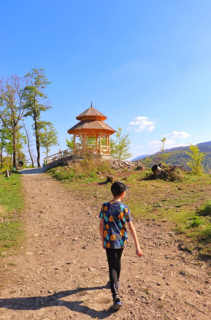 Dziecko na niebieskim szlaku na Kozią Górę idące do drewnianej altany widokowej