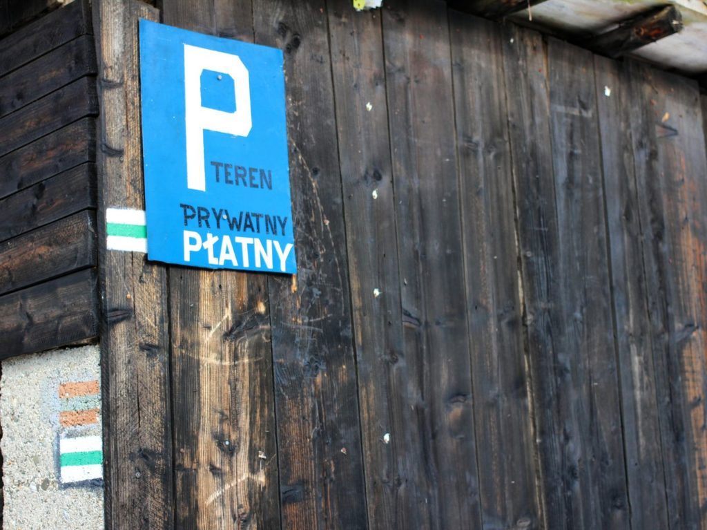 Niebieska tablica oznaczająca parking oraz teren prywatny, oznaczenie zielonego szlaku prowadzącego na Stożek Wielki z Wisły