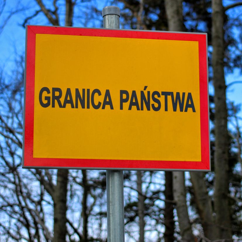 Żółta tablica z czerwoną ramką z napisem granica państwa umieszczona na szczycie Stożek Wielki 