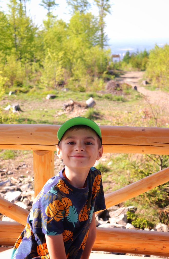Uśmiechnięte dziecko odpoczywające w drewnianej altanie na Koziej Górze