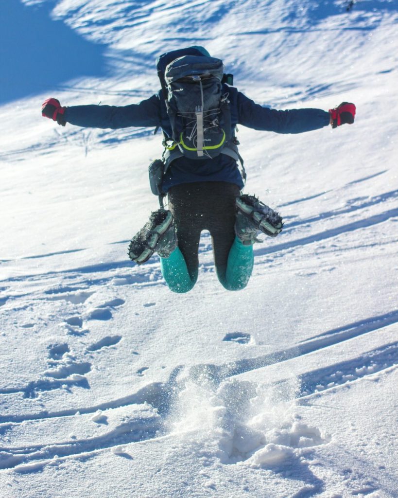 Skacząca w śniegu kobieta, odwrócona tyłem