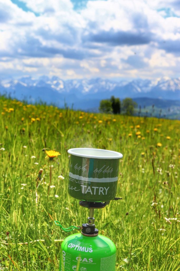 Rzepiska (Pieniny Spiskie), zielona butla z gazem, zielony kubek z białym napisem Tatry, polana, w tle widok na Tatry