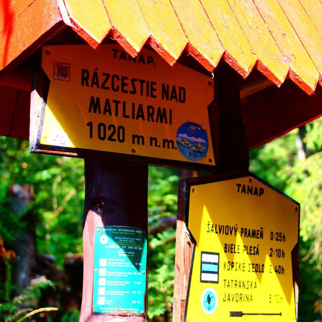 Żółta tablica oznaczająca Rozdroża nad Matlarami, wskazująca wysokość 1020 metrów nad poziomem morza