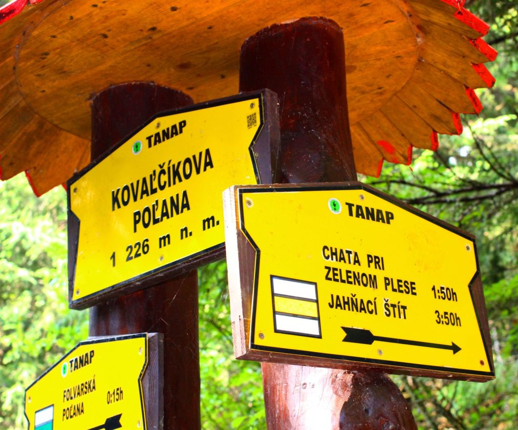 Żółta tabliczka oznaczająca - Kovalcikova Polana położona na 1226 metrów nad poziomem morza, druga żółta tabliczka informująca nas, że żółtym szlakiem 1 godzina 50 minut do Chaty przy Zielonym Stawie 