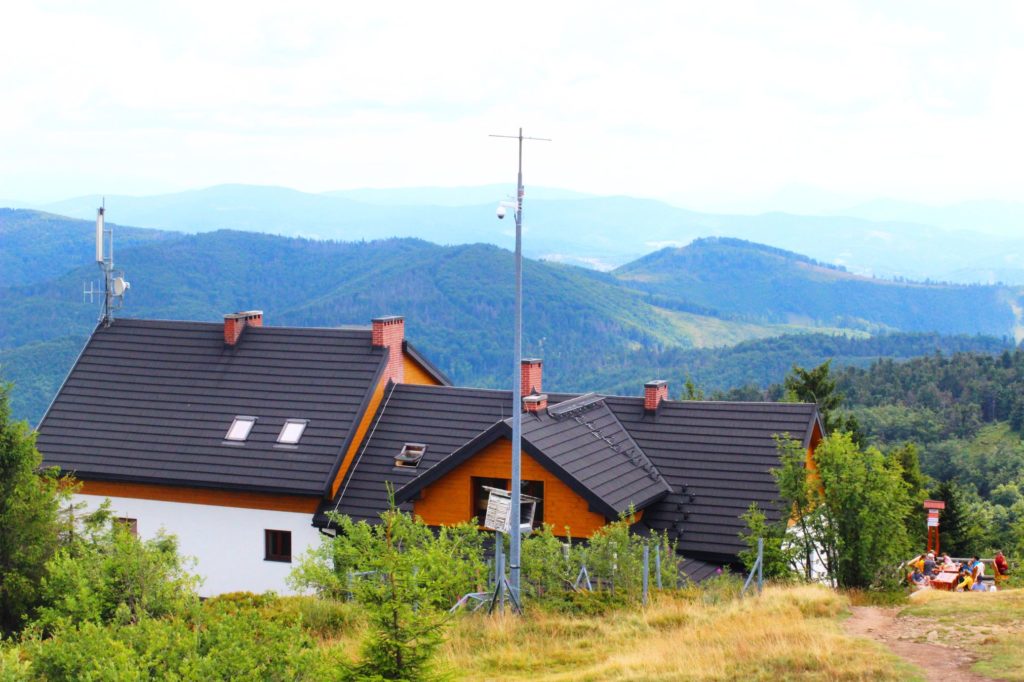 Widok z platformy wiokowej na schronisko na Wielkiej Raczy, w tle zamglone góry