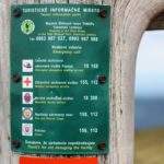 Zielona tablica informacyjna z numerami kontaktowymi do słowackich służb