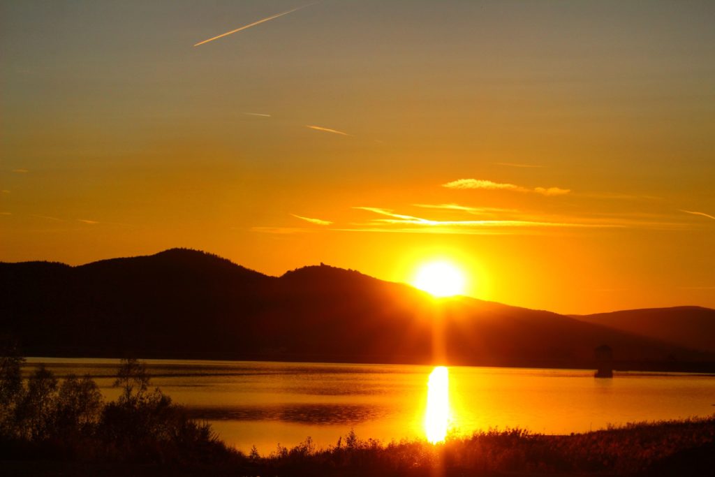 Góry Izerskie o zachodzie słońca, oświetlone przez zachodzące słońce jezioro