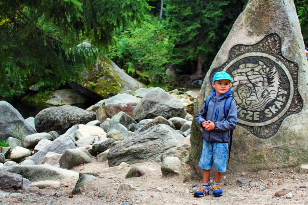 dziecko stojące przy skale z napisem Krucze Skały