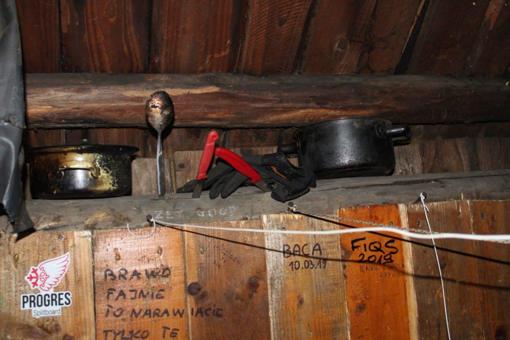 wewnątrz drewnianego szałasu na Męralowej, stare garki, noże, łyżeczka i rękawiczki