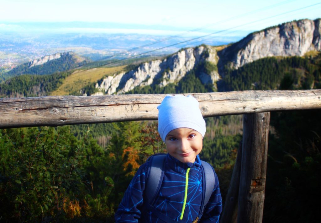 uśmiechające się dziecko na tarasie widokowym na zielonym szlaku na Kasprowy Wierch, w tle skały