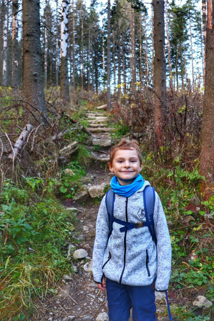 uśmiechnięto dziecko na ścieżce leśnej