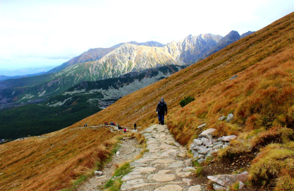 zejście z Kasprowego Wierchu żółtym szlakiem do Hali Gąsienicowej, wąska dróżka schodząca w dół między tatrzańskimi szczytami