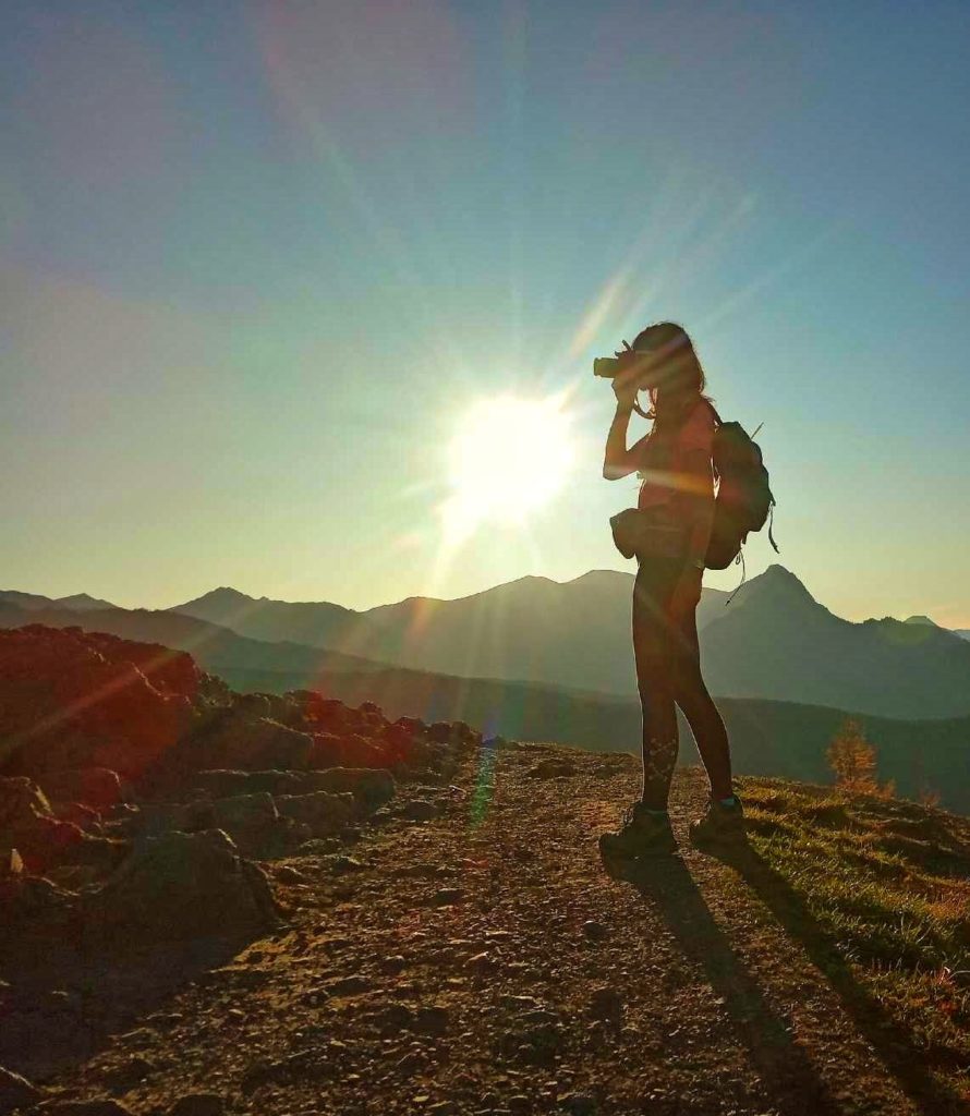 kobieta z aparatem na szczycie Wielki Kopieniec fotografująca Tatrzańskie szczyty, na niebie pełne słońce