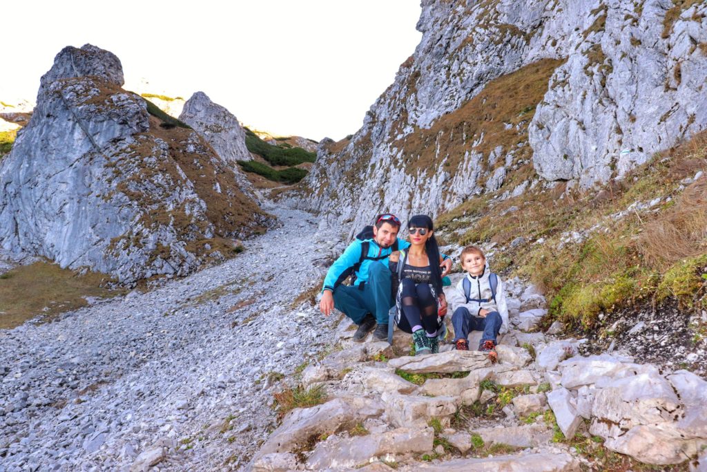 trzyosobowa rodzina siedząca na skałach tuż przed miejscem noszącym nazwę Kobylarzowy Żleb