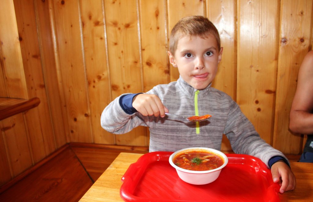 Dziecko jedzące zupę pomidorową w schronisku pod Łabskim Szczytem