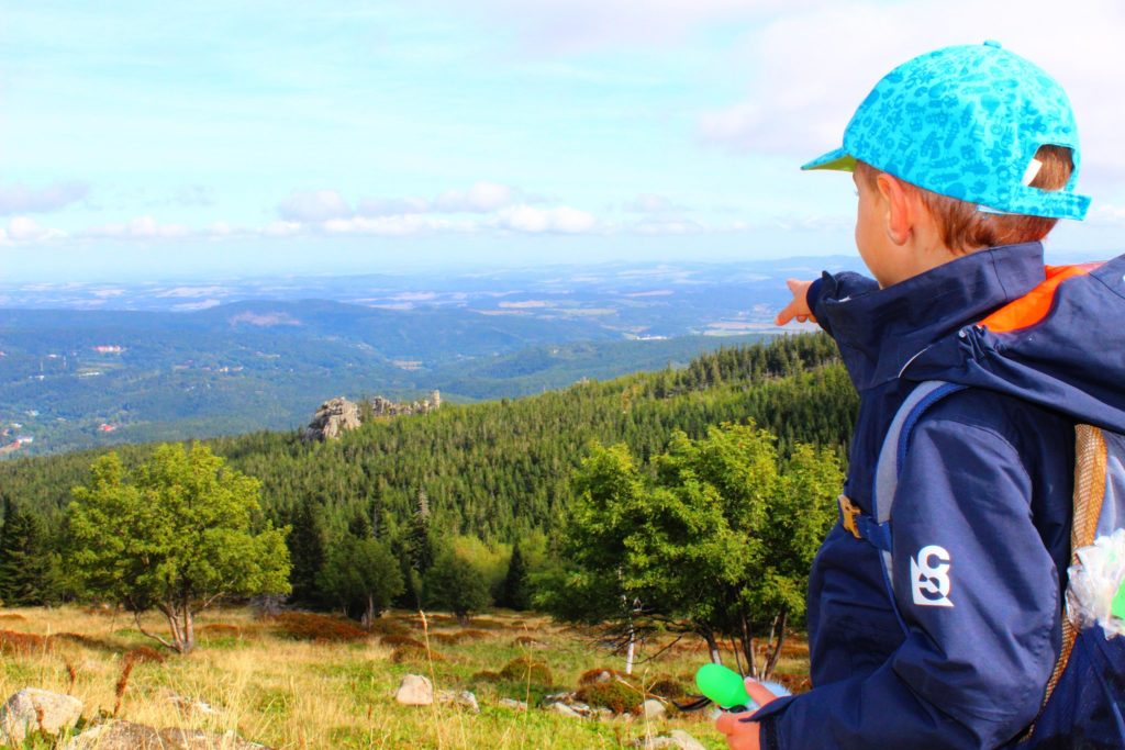 Dziecko pod Łabskim Szczytem pokazuje paluszkiem na wynurzające się w oddali góry