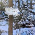 Tabliczka Tatrzańskiego Parku Narodowego opisująca szlak niebieski prowadzący na Halę Stoły z Doliny kościeliskiej, w koło zima