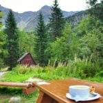 Biała miseczka z zupą czosnkową i grzankami leżąca na stoliku przed bufetem Rohackim, w tle Tatry