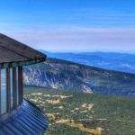 Kawałek budynku obserwatorium na szczycie Śnieżka oraz rozciągająca się ze szczytu panorama