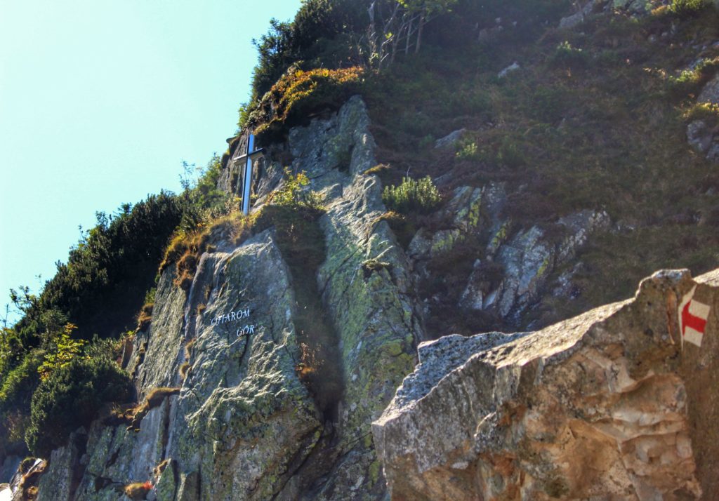 Metalowy krzyż Ofiarom Gór stojący na skałach na czerwonym szlaku idącym w kierunku szczytu Śnieżki