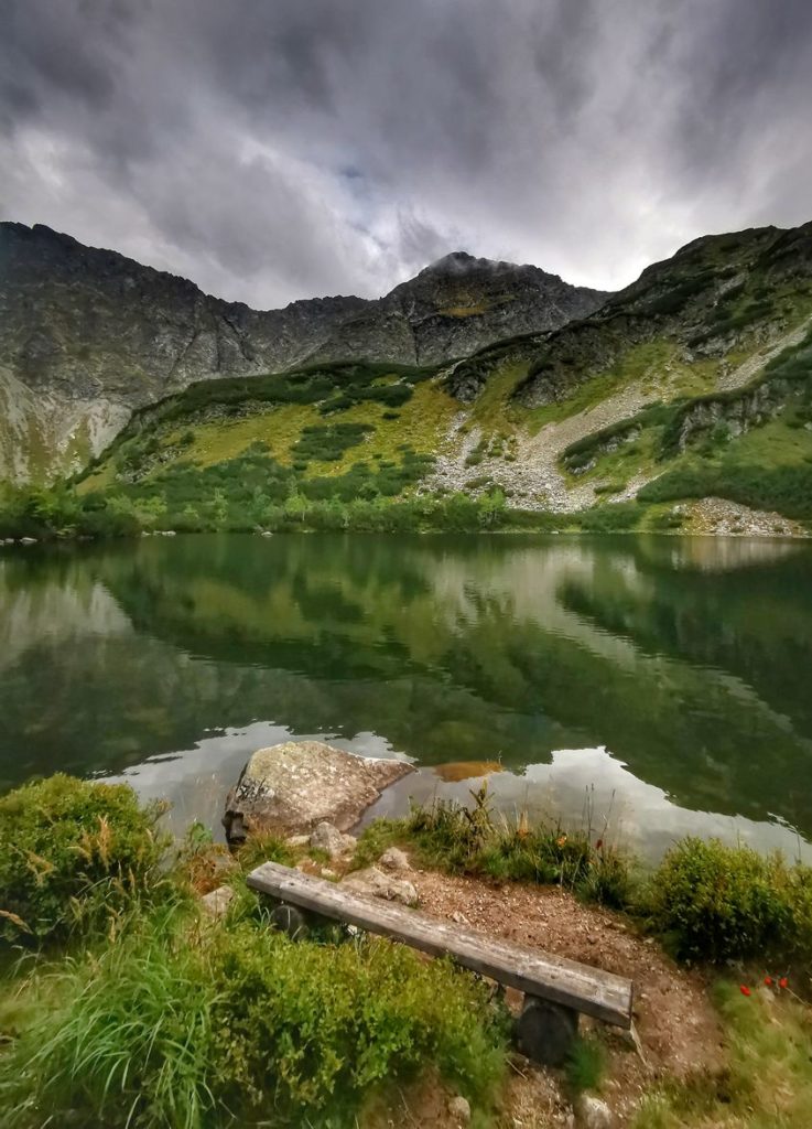 Piękny Niżni Staw Rohacki na Słowacji, drewniana ławeczka, widok na tatrzańskie szczyty