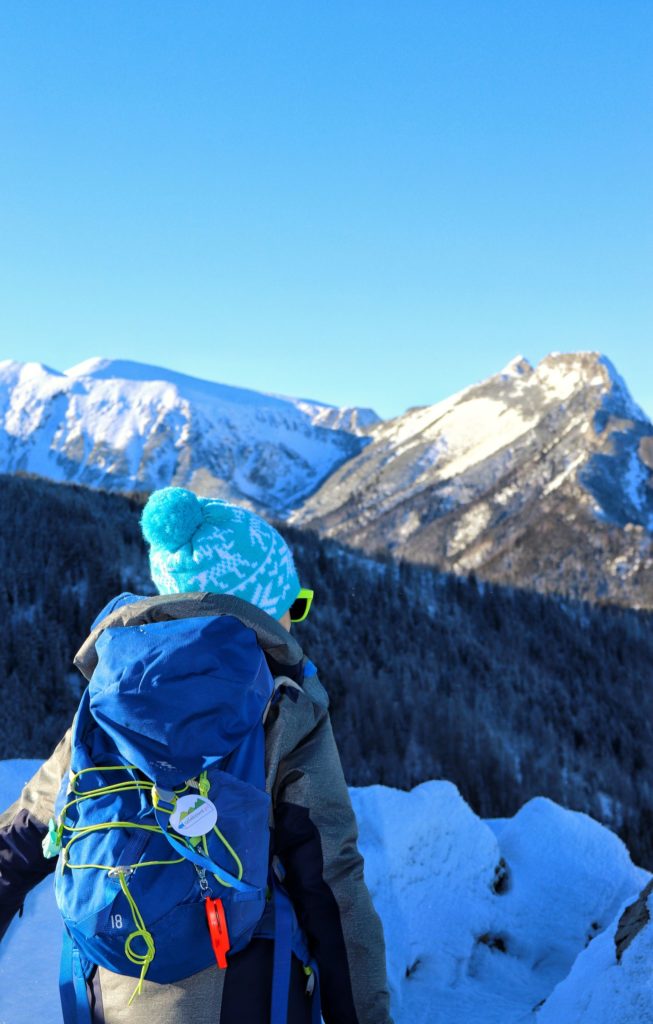 Dziecko podziwiające zaśnieżone, tatrzańskie szczyty (Giewont) ze szlaku niebieskiego idącego na Halę Gąsienicową