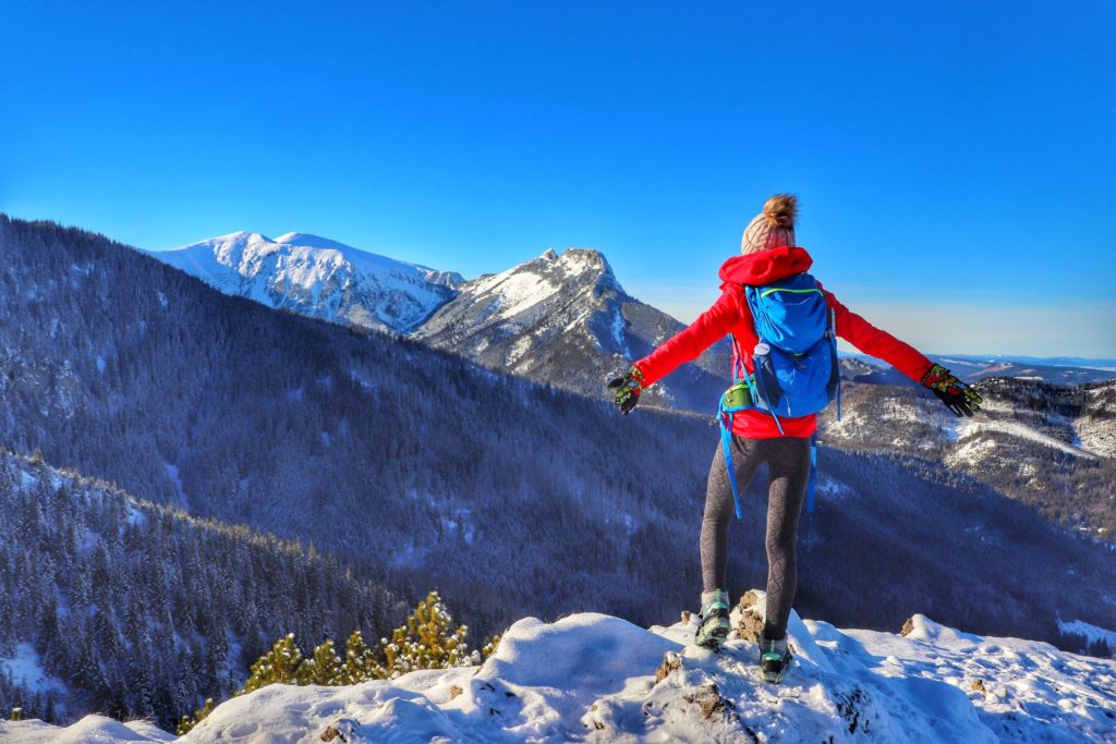Turystka podziwiająca zimowe widoki rozciągające się ze szlaku niebieskiego na Halę Gąsienicową