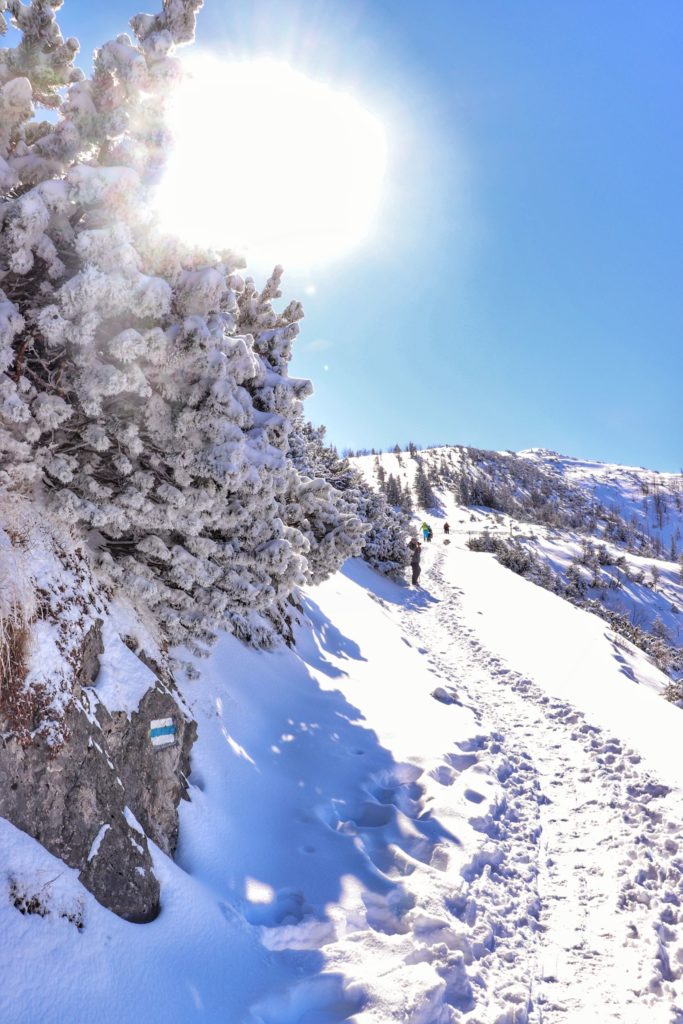 Wąska, zaśnieżona ścieżka tuż przed Przełęczą między Kopami, błękitne niebo, pełne słońce